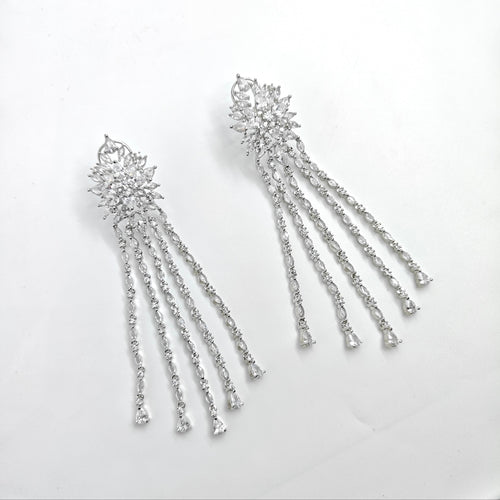 Pair of silver earrings with dangling elements on a white background