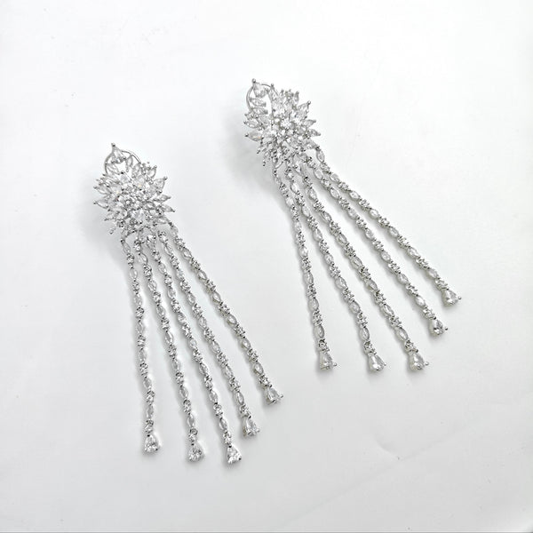 Pair of silver earrings with dangling elements on a white background