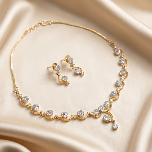 Gold necklace and earrings set on a beige fabric background