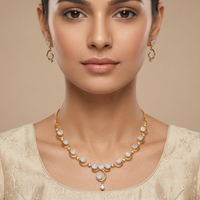 Woman wearing a gold necklace and earrings on a beige background