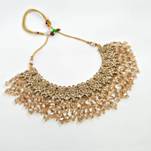 Gold beaded necklace on a white background