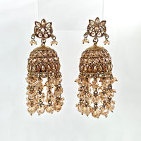 Pair of ornate gold earrings with crystal-like stones on a white background