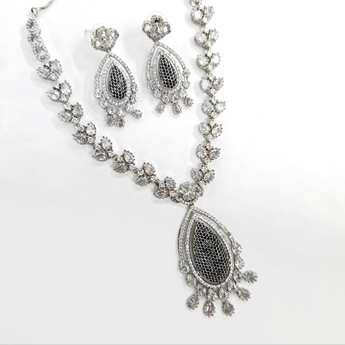 Silver necklace and earrings set on a white background