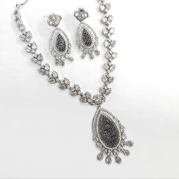 Silver necklace and earrings set on a white background