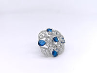Elegant brooch with blue and clear gemstones on a white background