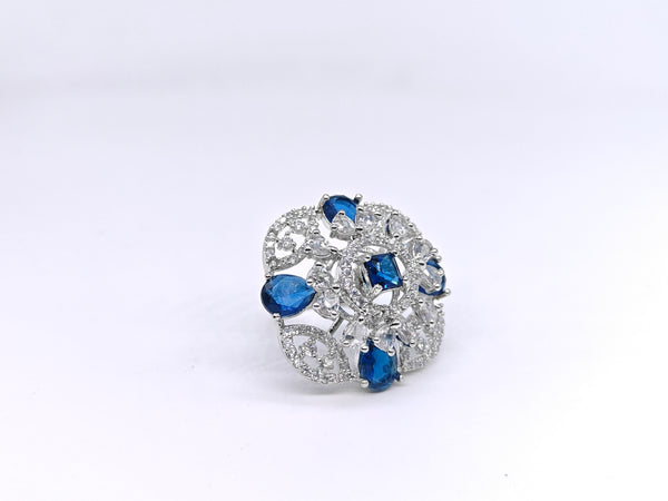 Elegant brooch with blue and clear gemstones on a white background