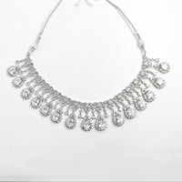 Silver necklace with teardrop-shaped pendants on a white background