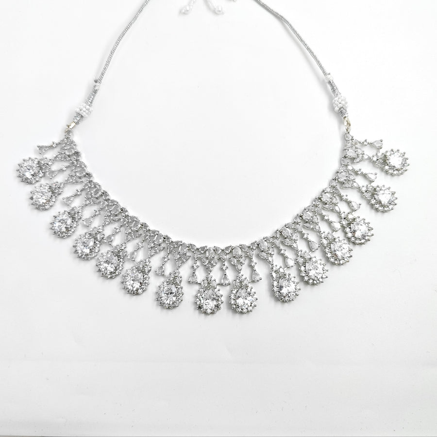 Silver necklace with teardrop-shaped pendants on a white background