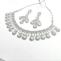 Silver necklace and earrings set on a white background
