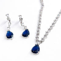 Set of blue teardrop pendants on silver chains against a white background