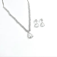 Silver necklace and earrings set on a white background