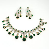 Jewelry set with necklace and earrings featuring green gemstones on a white background