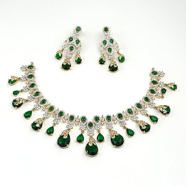 Jewelry set with necklace and earrings featuring green gemstones on a white background