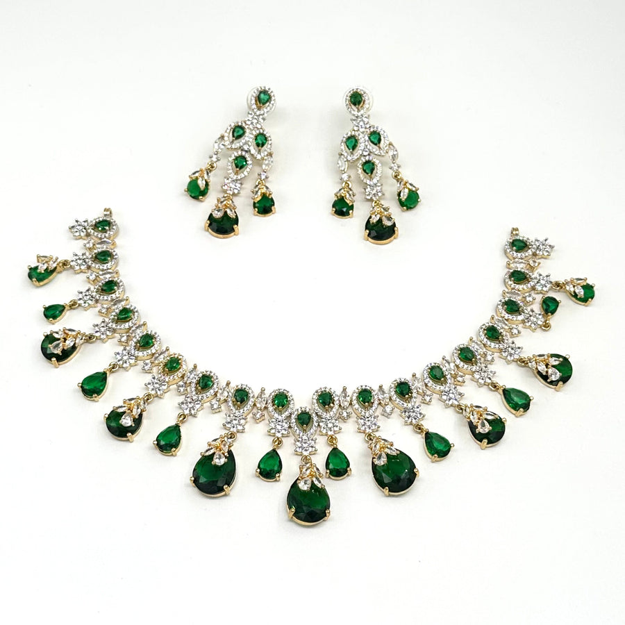Jewelry set with necklace and earrings featuring green gemstones on a white background