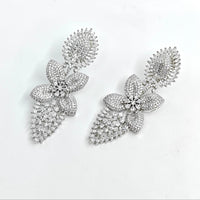 Silver floral earrings with clear stones on a white background
