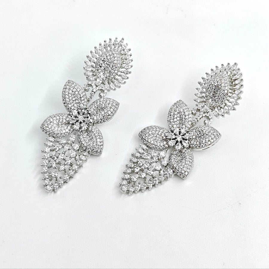 Silver floral earrings with clear stones on a white background