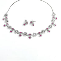 Jewelry set with necklace and earrings featuring pink gemstones on a white background