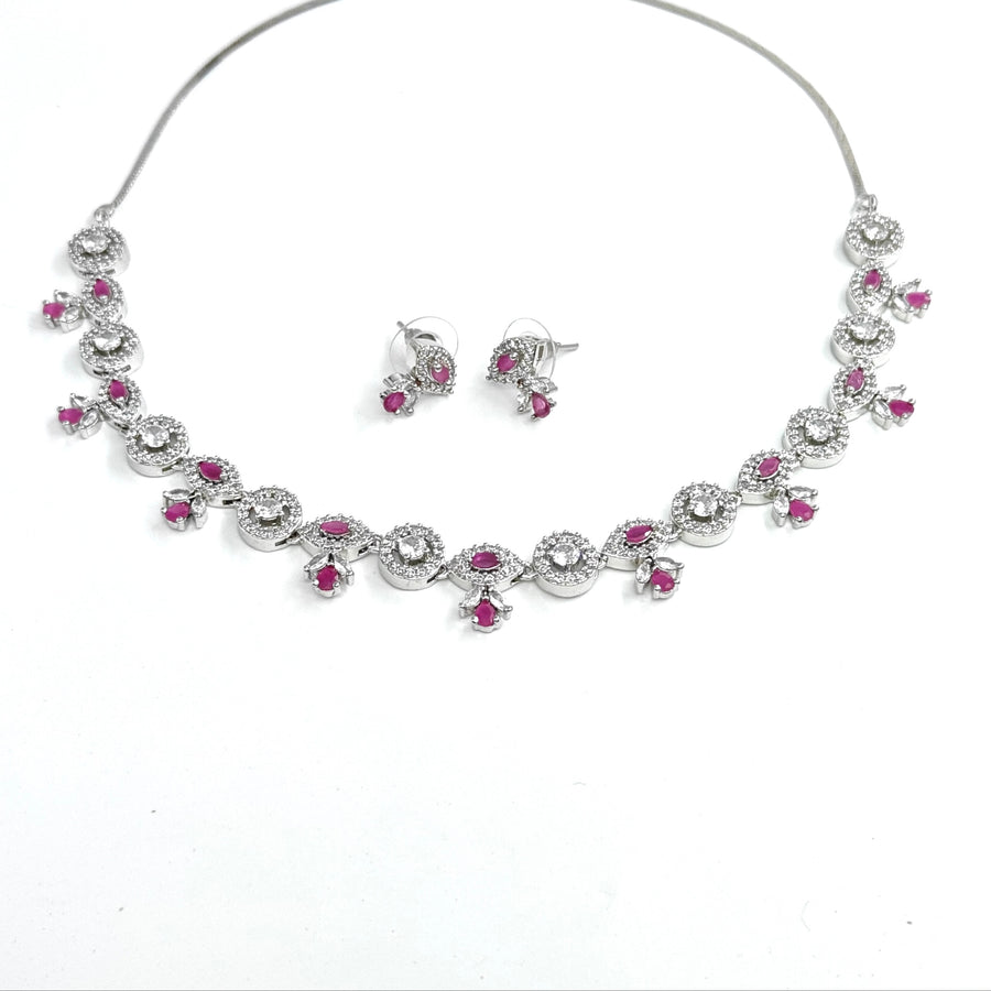 Jewelry set with necklace and earrings featuring pink gemstones on a white background
