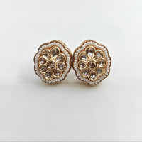 Pair of floral earrings with gold and crystal details on a white background