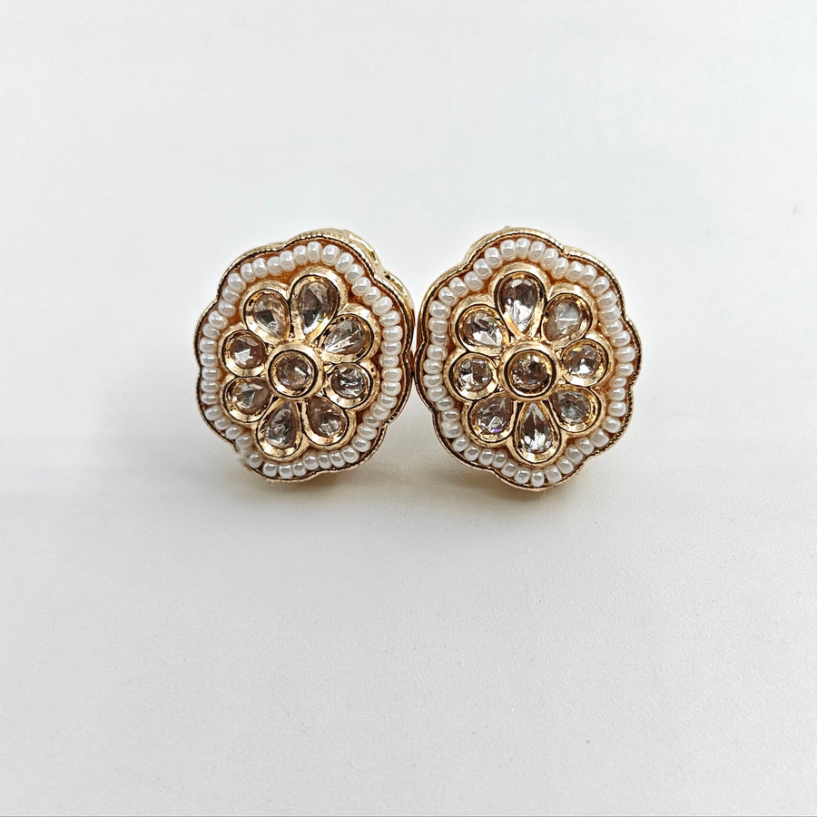 Pair of floral earrings with gold and crystal details on a white background