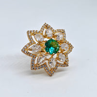 Gold ring with a green gemstone on a white background