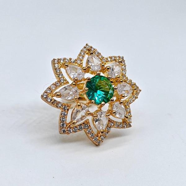 Gold ring with a green gemstone on a white background