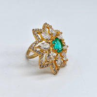 Gold ring with a green gemstone on a white background