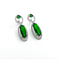 Green gemstone earrings with silver accents on a white background