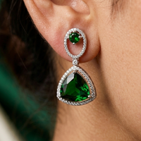 Close-up of a person wearing a green gemstone earring.