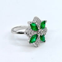 Silver ring with green gemstones on a white background
