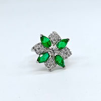 Silver ring with green gemstones on a white background