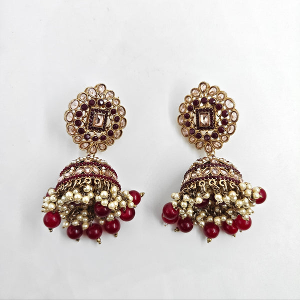 Ornate earrings with red and gold details on a white background