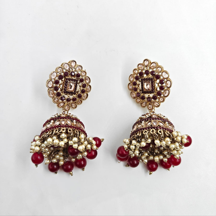 Ornate earrings with red and gold details on a white background