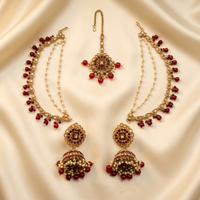 Gold and red jewelry set on a beige fabric background