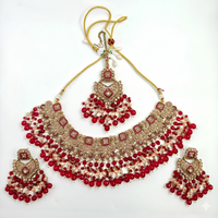 Jewelry set with necklace, earrings, and tikka on a white background