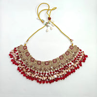 Decorative necklace with red and gold beads on a white background