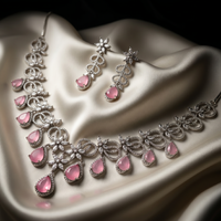 Jewelry set with pink gemstones on a white fabric background