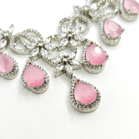 Pink teardrop-shaped gemstones with silver prongs on a white background