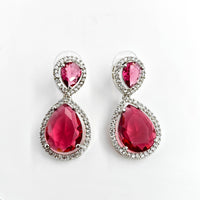 Pair of earrings with red gemstones on a white background