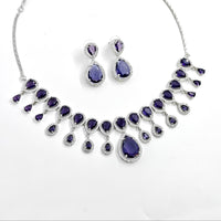 Jewelry set with purple teardrop-shaped stones on a white background