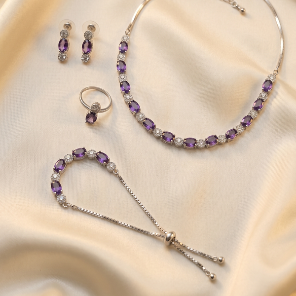 Jewelry set with purple gemstones on a beige fabric background