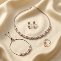 Jewelry set with pink stones on a beige fabric background
