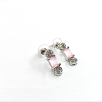 Silver earrings with pink gemstones on a white background