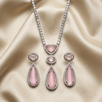 Pink teardrop jewelry set on a beige satin background