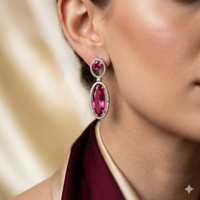 Close-up of a woman wearing a pair of pink gemstone earrings.