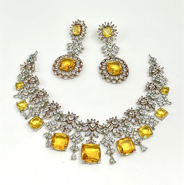 Jewelry set with necklace and earrings featuring yellow gemstones on a white background