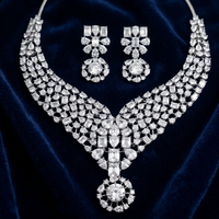 Diamond necklace and earrings set on a dark blue velvet background