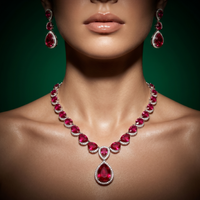 Red gemstone necklace and earrings on a mannequin against a dark green background