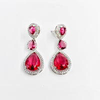 Pair of red teardrop earrings with silver accents on a white background