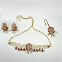 Set of traditional Indian jewelry including a necklace, earrings, and a bracelet on a white background.